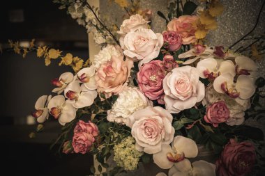 Duvar ile bir vazoda gül buketi.