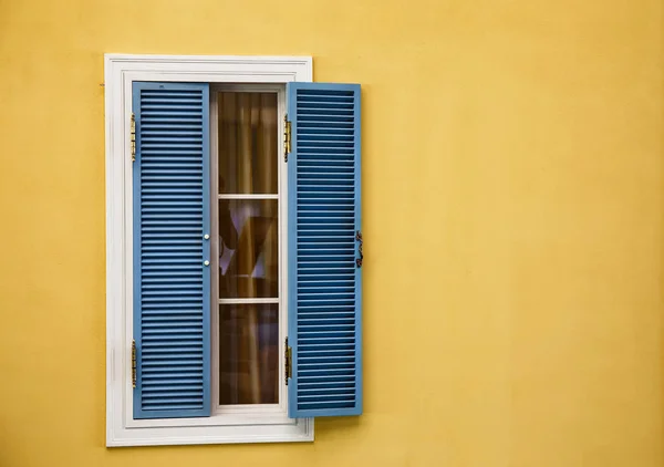 Wooden windows on yellow walls — Stock Photo, Image