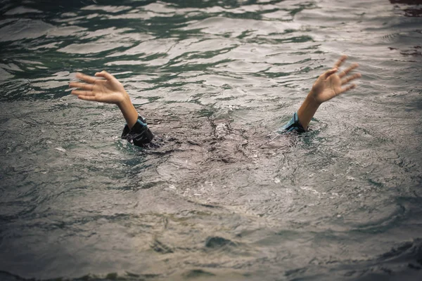 La gente ahogada levanta las manos para pedir ayuda en la piscina . Imagen de stock