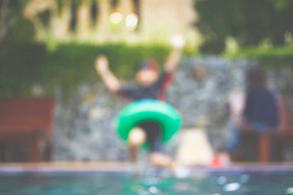 Niño nadando junto a la piscina imagen borrosa . — Foto de Stock