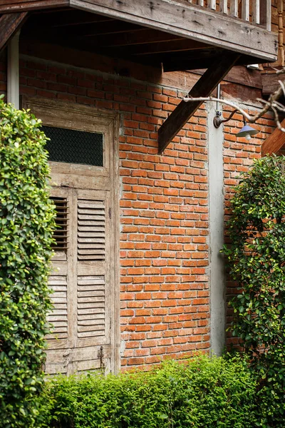 Oude houten deur op bakstenen muur. — Stockfoto