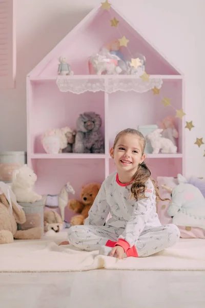 Девушка в пижаме в детской комнате — стоковое фото