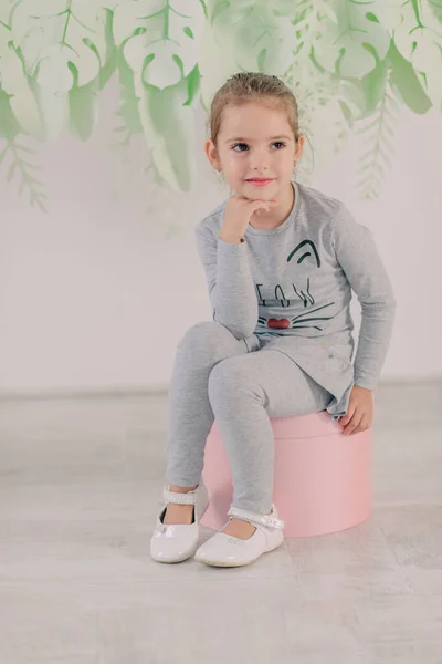 Klein meisje in een grijs pak — Stockfoto