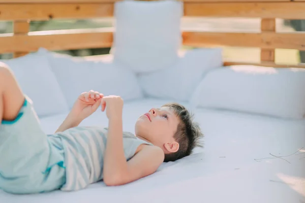 Junge in kurzen Hosen liegt auf der Couch — Stockfoto