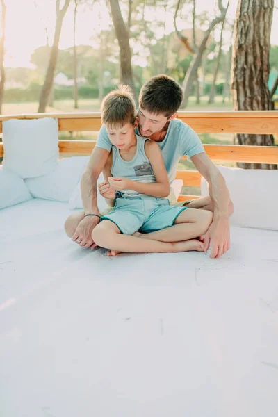 Fils avec son père sur un canapé en bois — Photo