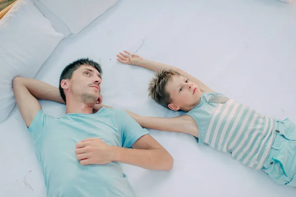 Pai e filho deitados na cama — Fotografia de Stock