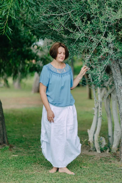 V parku pod stromem vystupují žena — Stock fotografie