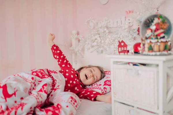 Meisje in de rode pyjama's slapen in bed — Stockfoto