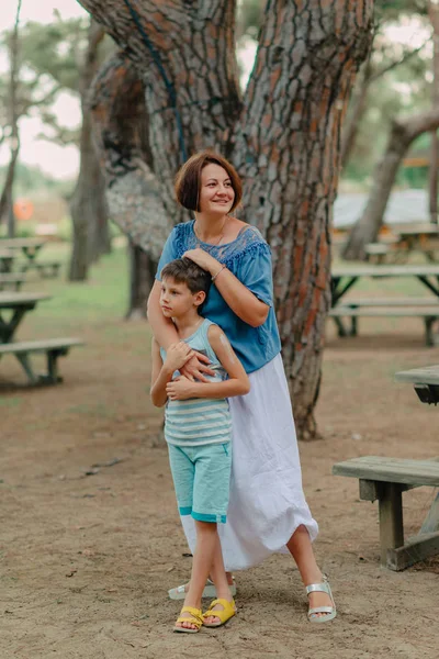 Mãe com o menino no parque debaixo de uma árvore — Fotografia de Stock