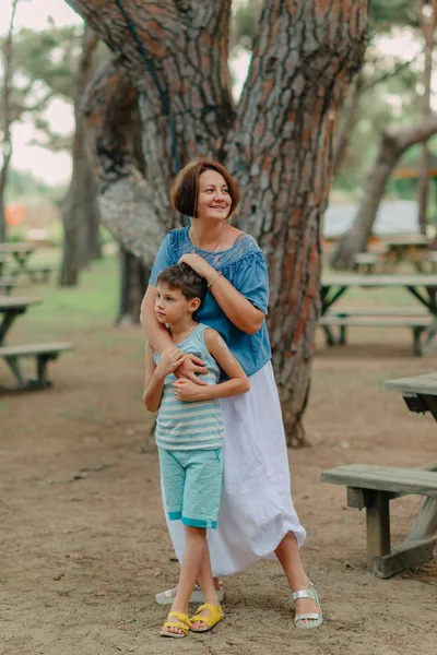 Mutter mit kleinem Jungen im Park unter einem Baum — Stockfoto