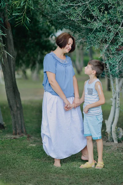 Mãe com o menino no parque debaixo de uma árvore — Fotografia de Stock