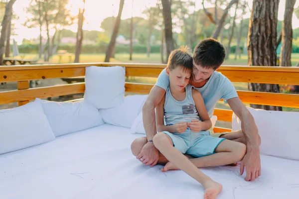 Zoon met zijn vader op een houten bank — Stockfoto