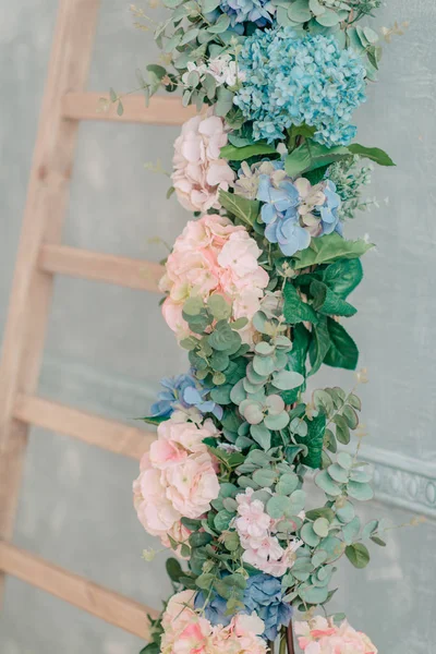 Sur un escalier en bois une guirlande de fleurs — Photo