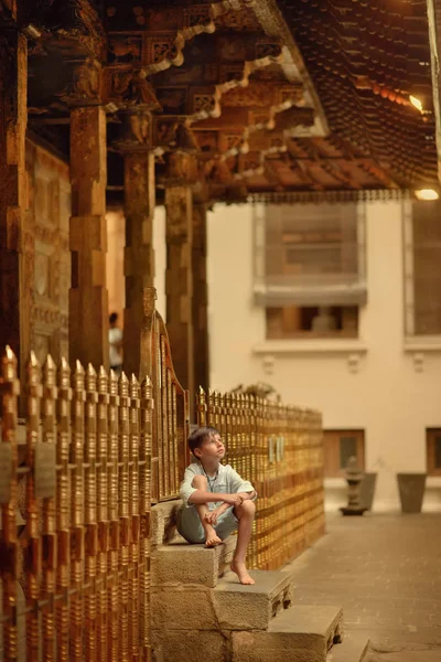 Il ragazzo è seduto sotto il portico — Foto Stock