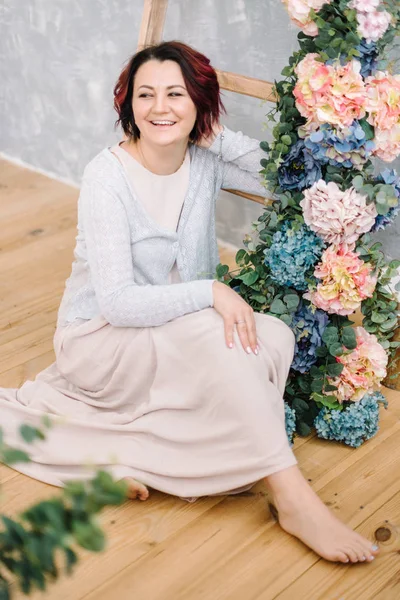 Frau an der Holztreppe und Blumengirlande — Stockfoto