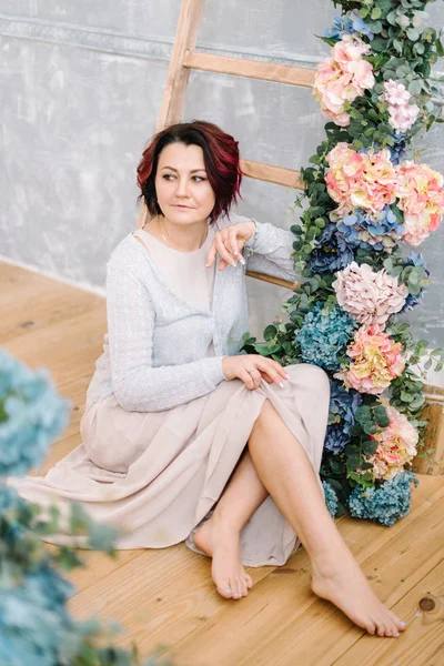 Žena na dřevěné schodiště a květinový věnec — Stock fotografie