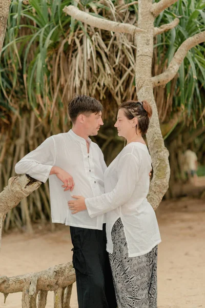 A woman with a man under a palm tree — Stock Photo, Image