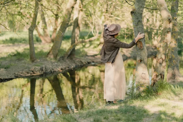 Mulher de chapéu na floresta junto ao rio — Fotografia de Stock
