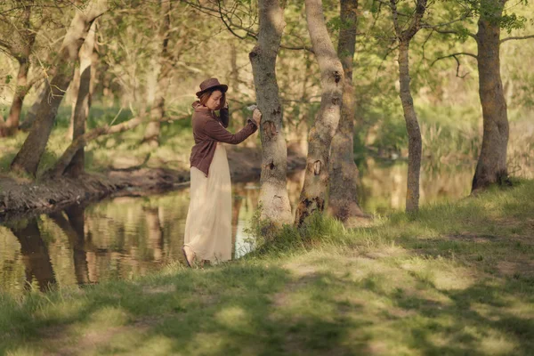 Mujer en sombrero en el bosque junto al río —  Fotos de Stock