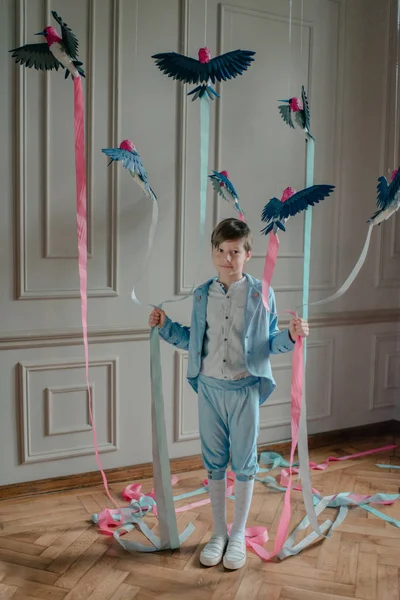 The boy in blue suit with birds and ribbons — Stock Photo, Image