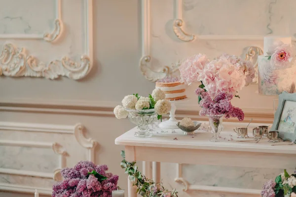 Mesa branca com buquês de flores — Fotografia de Stock