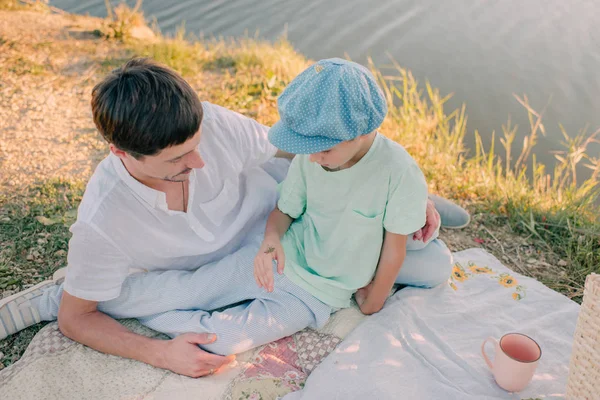 Père et fils sur la rive de la rivière sous le soleil brillant — Photo