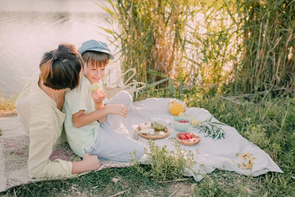 Anne ve oğlu parlayan güneşin altında Nehri kıyısında