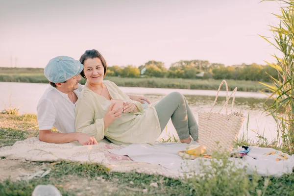 En flicka med mannen på flodstranden under skinande solen — Stockfoto