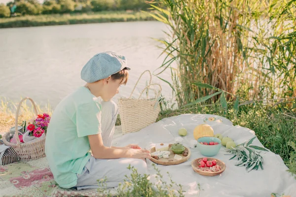 En pojke på flodstranden under skinande solen — Stockfoto