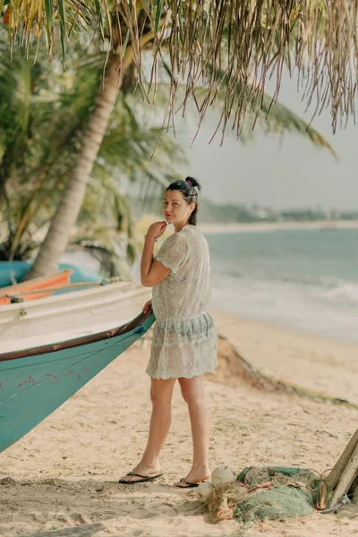 女孩在棕榈树下的海洋附近的船上举行 — 图库照片