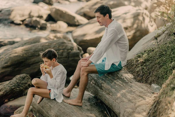 父と息子は 海の近くの岩で遊んでいます — ストック写真