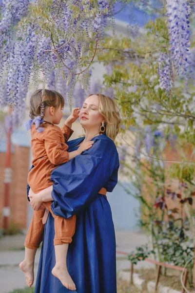 Mamá Con Una Hija Bajo Glicina Floreciente — Foto de Stock