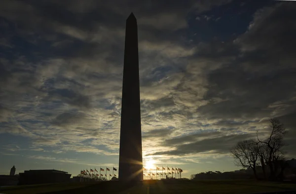 Солнце Движется Монументом Вашингтону Окружении Флагов Сша Против Голубого Неба — стоковое фото