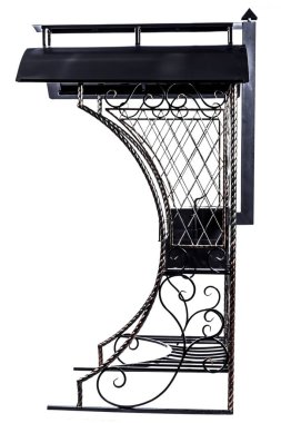 Çatılı barbekü ve beyaz arka planda işlenmiş demir süsler.