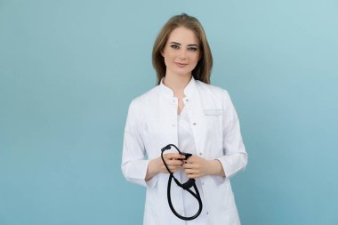 Elinde steteskop olan pozitif kadın doktor mavi arka planda.