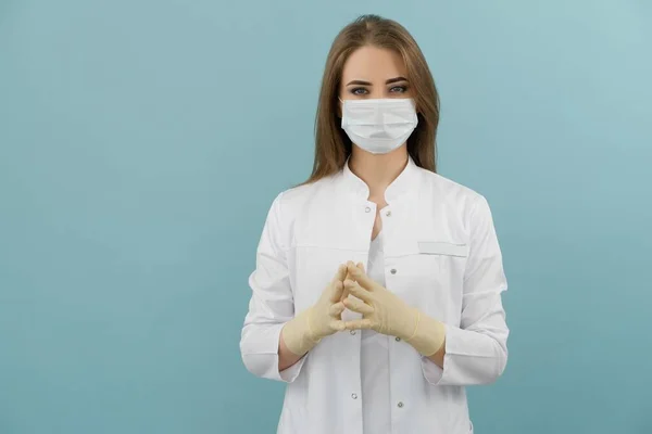 Maskeli beyaz kadın doktor ve mavi arka planda ceket.