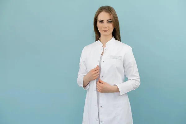 Mavi arka planda ceketli, pozitif doktor kadın.
