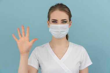 Maskeli kadın doktor mavi arka planda 1 'den 5' e kadar puan gösteriyor.