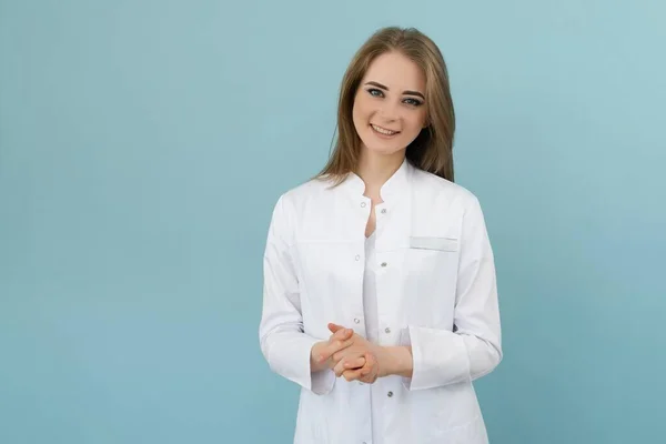 Mavi arka planda ceketli, pozitif doktor kadın.