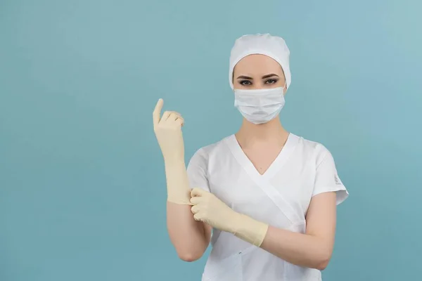 Maskeli kadın ve eldivenli doktor mavi arka planda ameliyata hazırlanıyor.