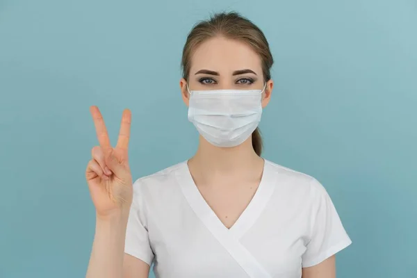 Maskeli kadın doktor mavi arka planda 1 'den 5' e kadar puan gösteriyor.