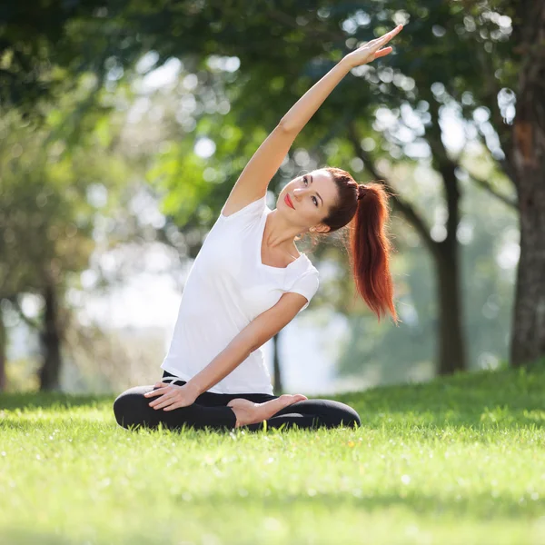 在公园里做瑜伽练习的漂亮女人 — 图库照片