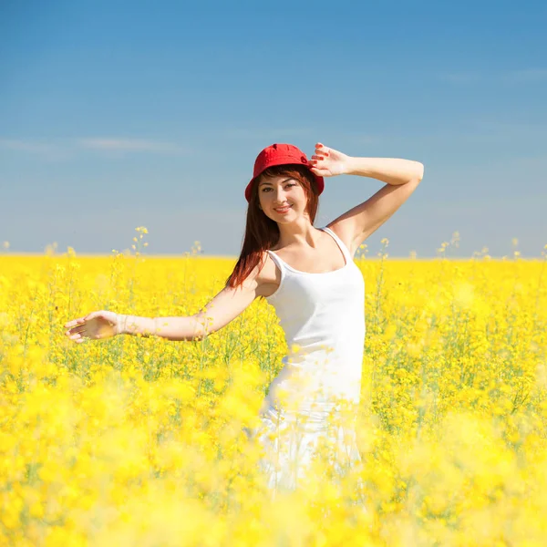 Happy woman in the field with flowers at sunny day in the countryside. Free woman enjoying the nature. Beautiful girl outdoor. Freedom concept. Woman over sky and field. Enjoyment and happiness — Stock Photo, Image