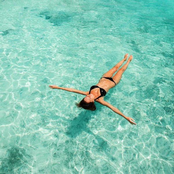 Frau entspannt sich auf blauen Wellen des Meeres. glücklicher Insellebensstil. Das kristallklare Wasser des tropischen Strandes. Urlaub im Paradies. Meer Strand entspannen, Reise zum Sommer Meer — Stockfoto