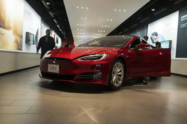 Tesla Model S elektrikli otomobil showroom etrafında tüketiciler ile ekranda.