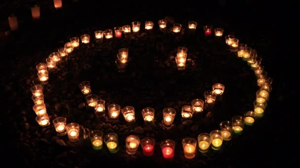 Palenie romantycznych świec przez kładzenie się jak znak uśmiechu w nocy — Wideo stockowe