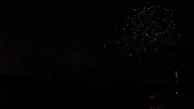 Yaz gecesi Tokyo 'daki şehir merkezindeki binanın yanında havai fişekler.