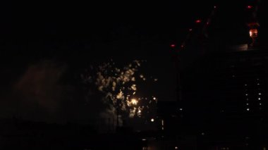 Yaz gecesi Tokyo 'daki şehir merkezindeki binanın yanında havai fişekler.