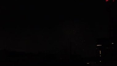 Yaz gecesi Tokyo 'daki şehir merkezindeki binanın yanında havai fişekler.