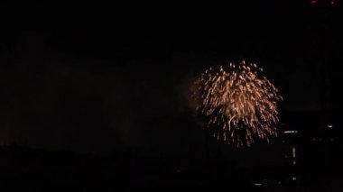 Yaz gecesi Tokyo 'daki şehir merkezindeki binanın yanında havai fişekler.